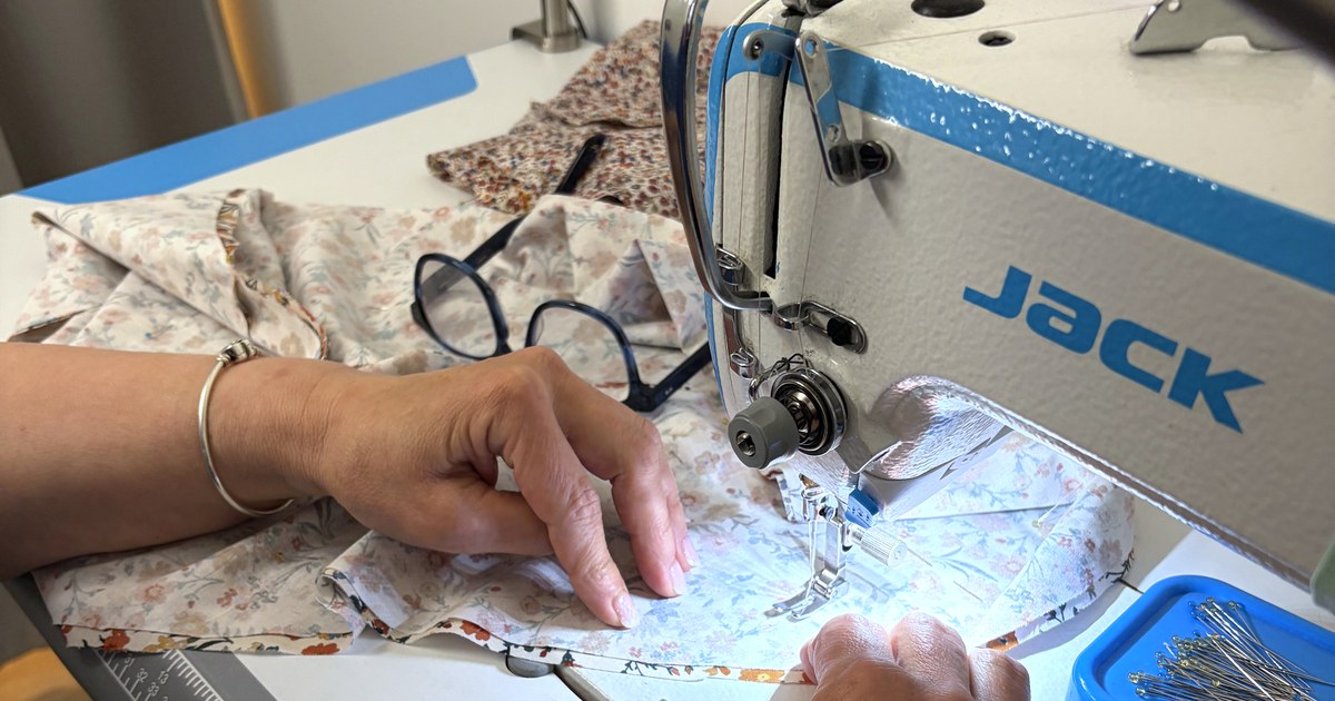 Atelier Hände der Schneiderin Zhanna an einer industriellen JACK-Nähmaschine mit floraler Stoffbahn — Krasota.Atelier, Zeughausmarkt 21, Hamburg