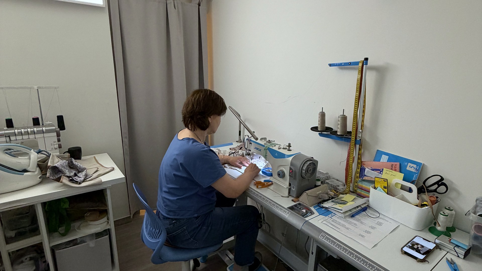 Atelier Atelier von Krasota.Atelier am Zeughausmarkt 21 in Hamburg — Arbeitsplatz der Schneiderin mit Industrie-Overlock, Maßband und Werkzeugen